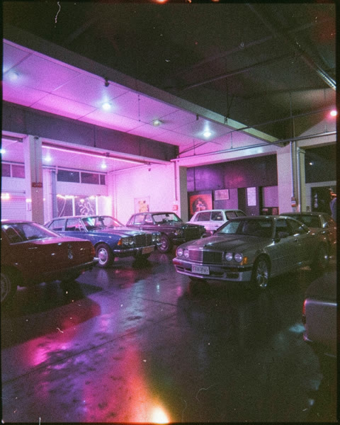 Des voitures dans un parking éclairé en violet