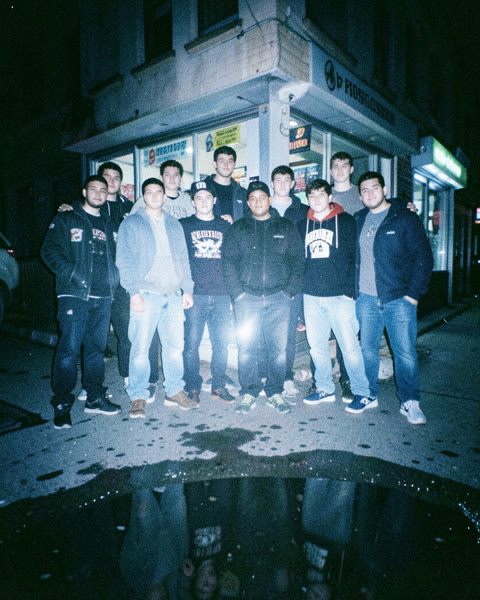 Un groupe pris au flash devant une épicerie, la nuit